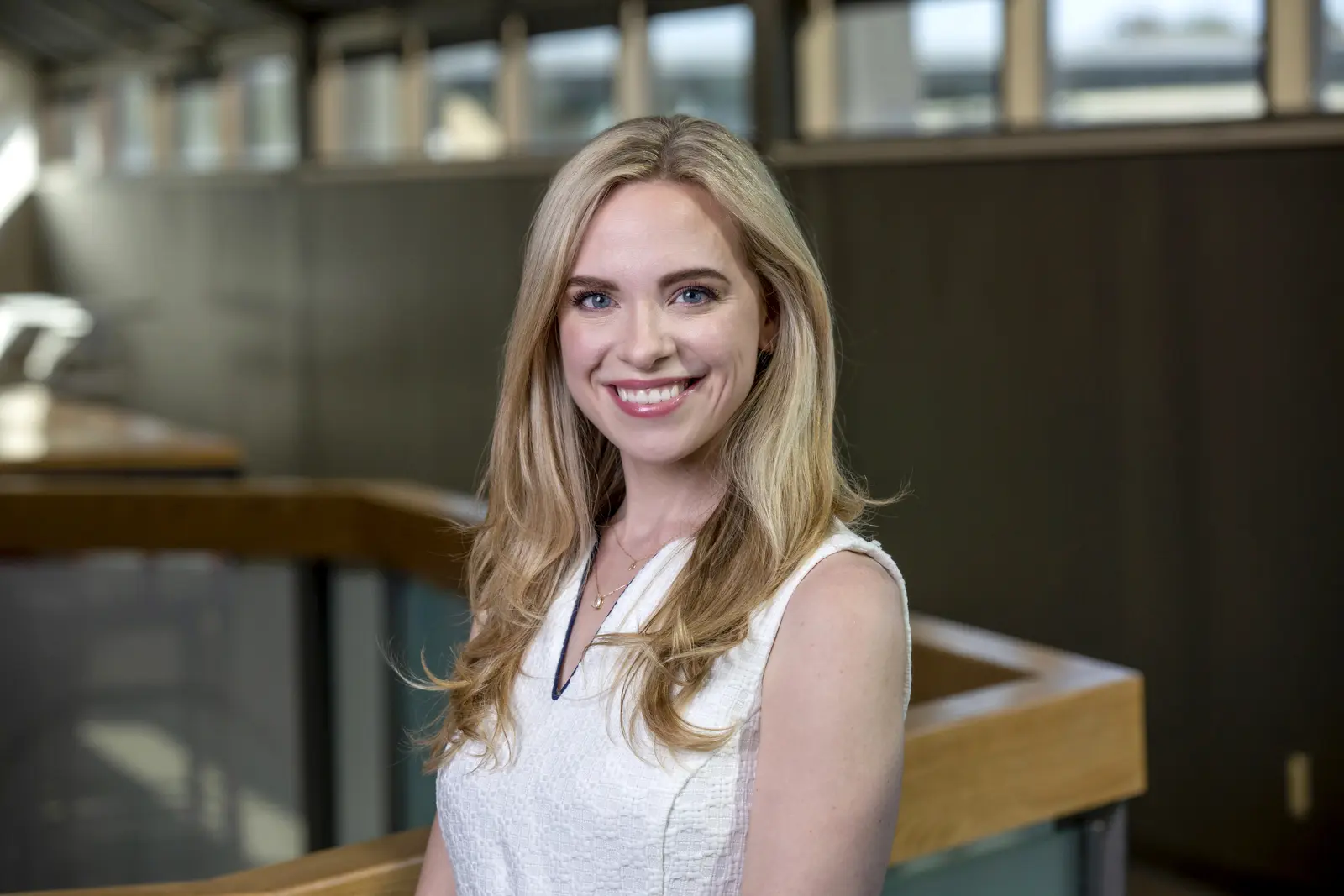 Head shot of a woman in a white blouse in a corporate environment