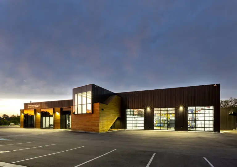 Architectural Photography of a manufacturing building for Tyson Foods photographed at sunrise with puffy clouds and a blue sky.