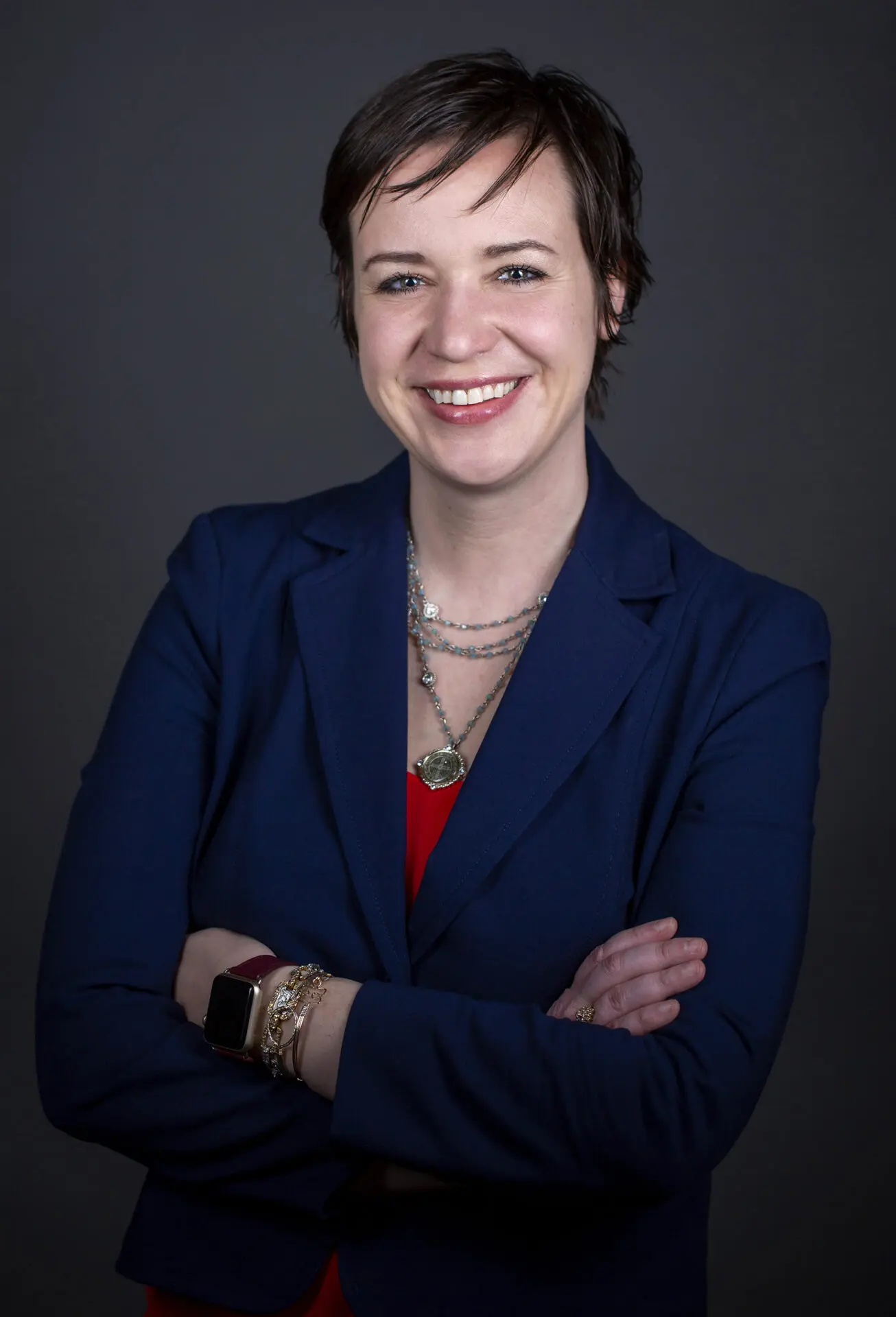 head shot of a woman taken in a photography studio on a dark background.