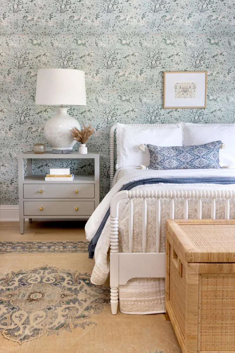 Interior photography of a little girls room with a spindle bed and floral wallpaper.