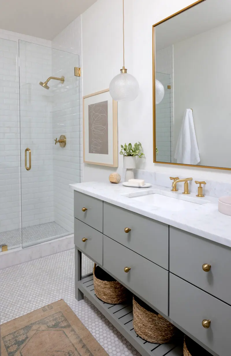 Interior photography of a bathroom with sage cabinets and white tile.