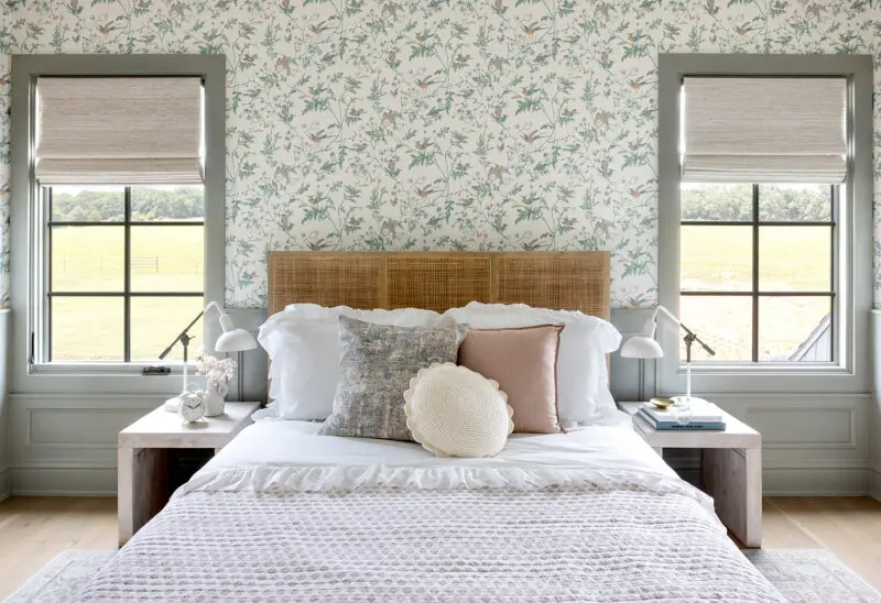 Interior photography of a little girls room with a rattan bed and floral wallpaper.