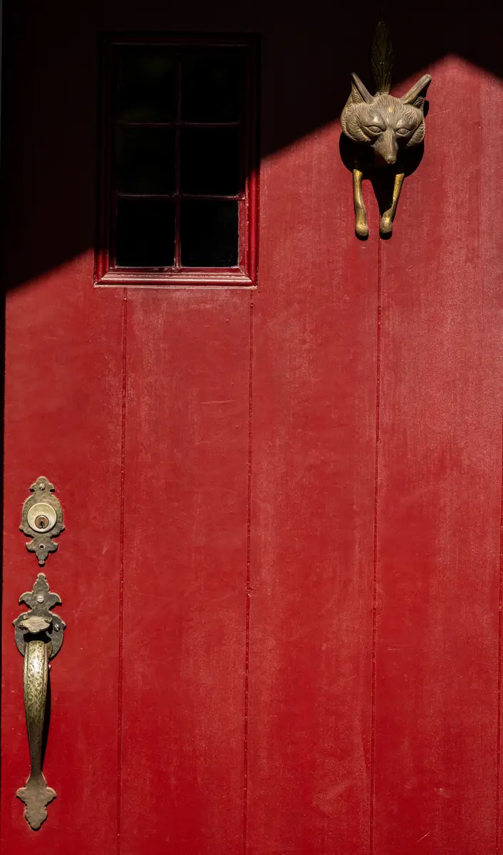 The red front door with brass details taken during an interior photoshoot in Fayetteville, Arkansas.