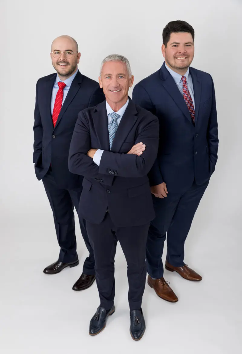 Group portrait of attorneys standing on a white backdrop.