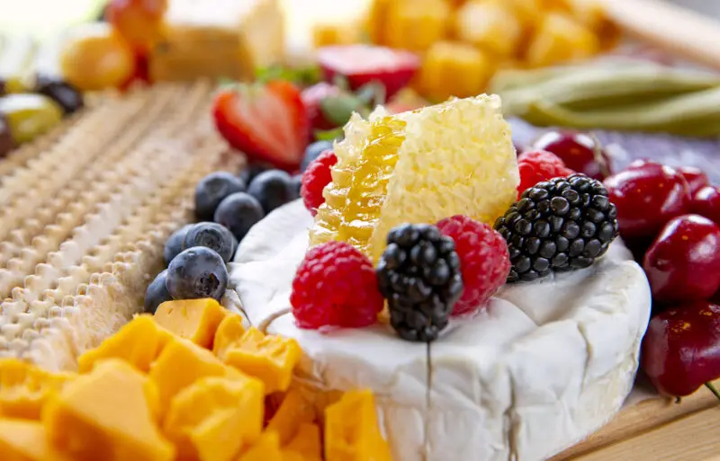 Food photography of a charcuterie board with crackers, honey and cheese taken for a magazine feature.