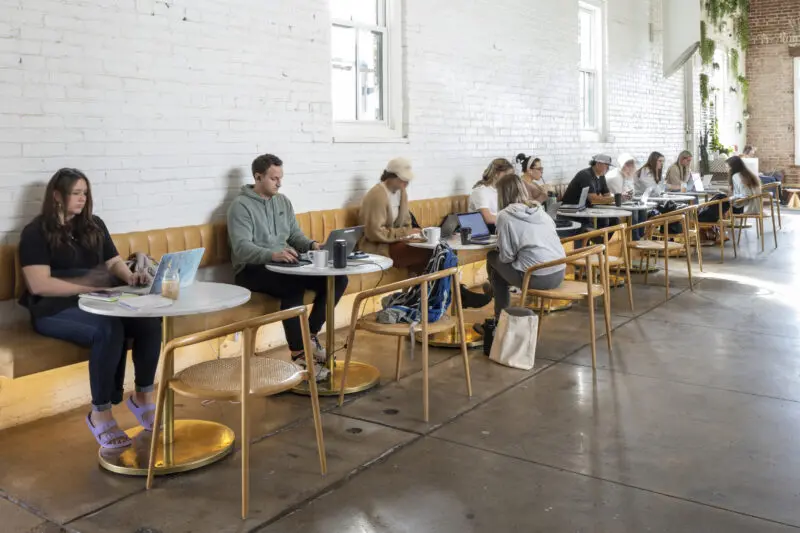 People are sitting in a row working and having coffee at Onyx Coffee House in Rogers, Ark.