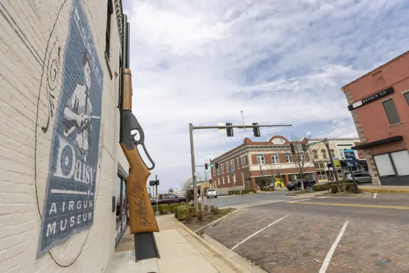 The Guiness Book of World Records largest bb gun leaning against a building in Rogers, Ark.