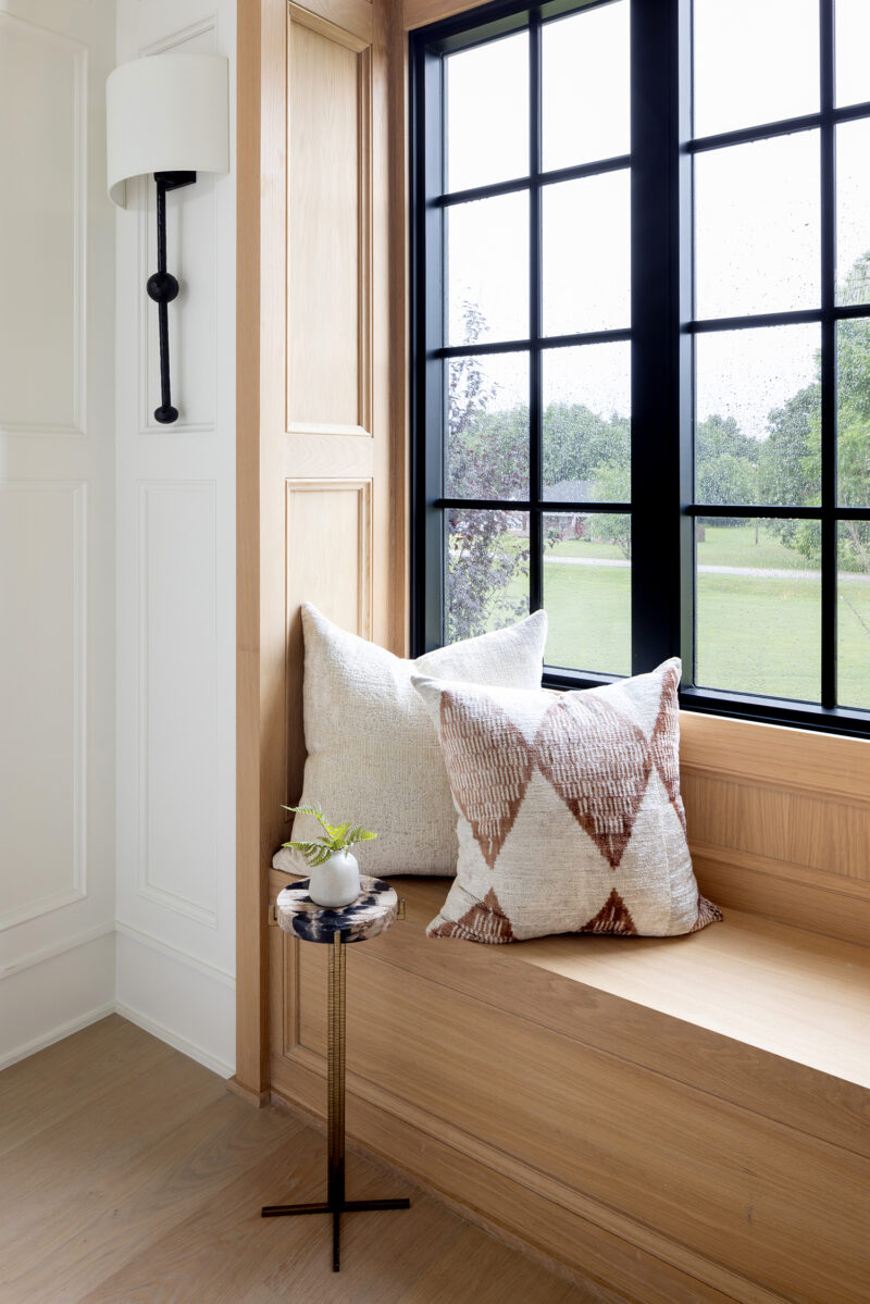 A windowsill seat decorate with pillows in neutral colors.