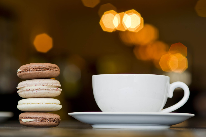 Coffee and a stack of macaroons at a coffee shop.