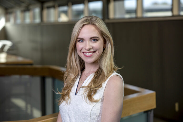 Head shot of a woman in a white blouse in a corporate environment