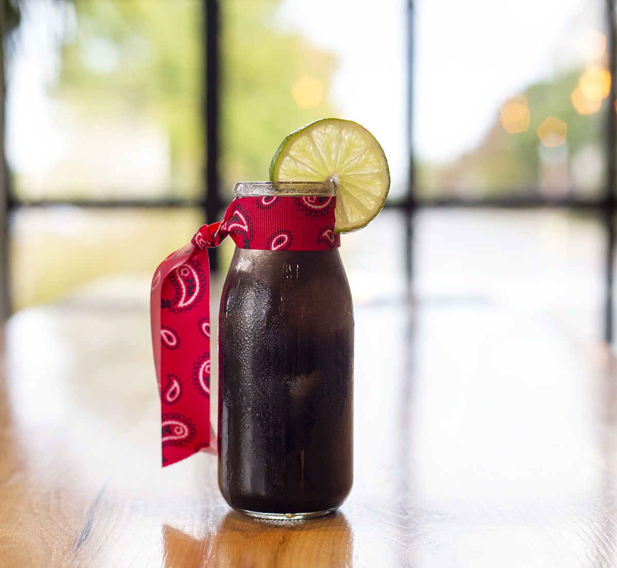 Photography of a coffee drink with a red bandana and a lime as garnish