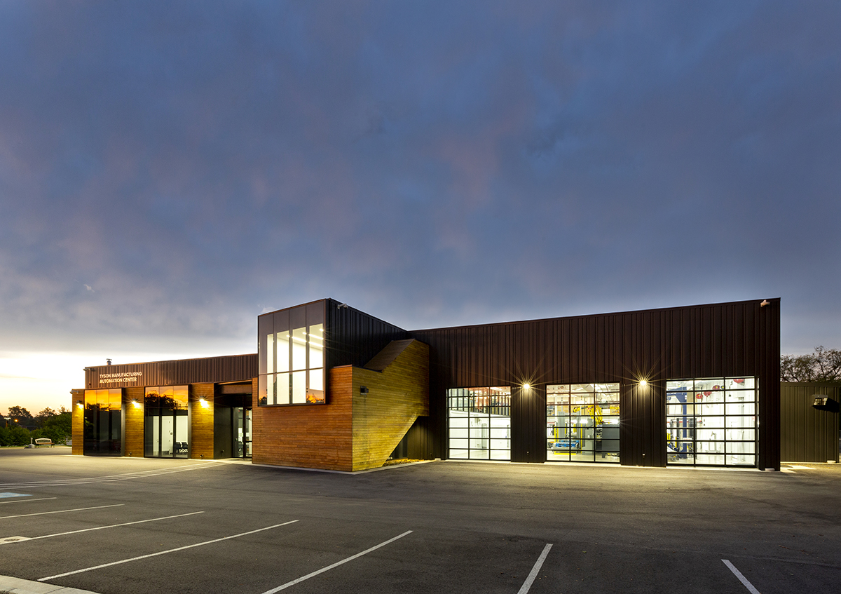 Architectural Photography of a manufacturing building for Tyson Foods photographed at sunrise with puffy clouds and a blue sky.