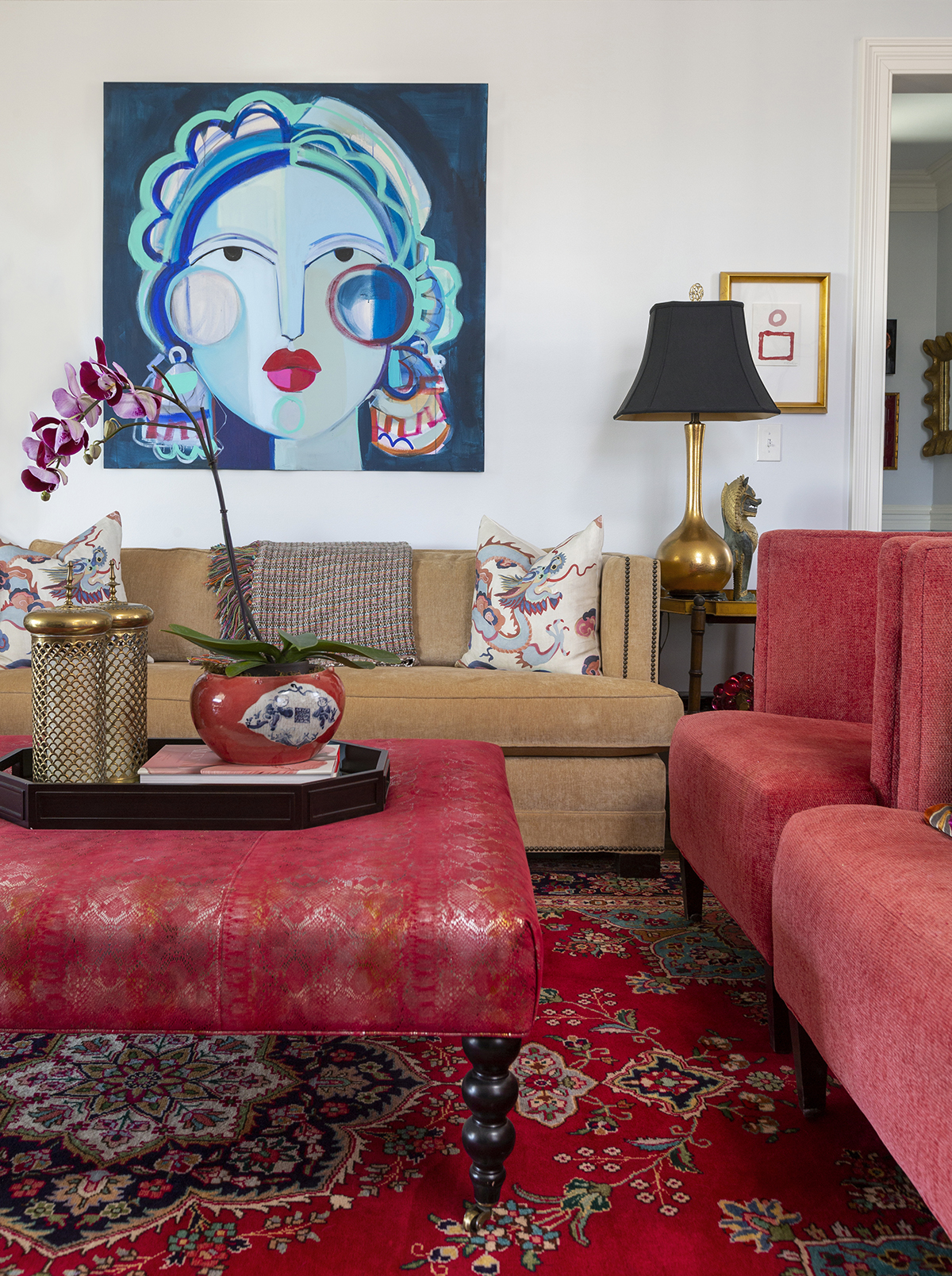 Interior Photography of a living room with pink chairs, and pink ottoman and a blue painting.