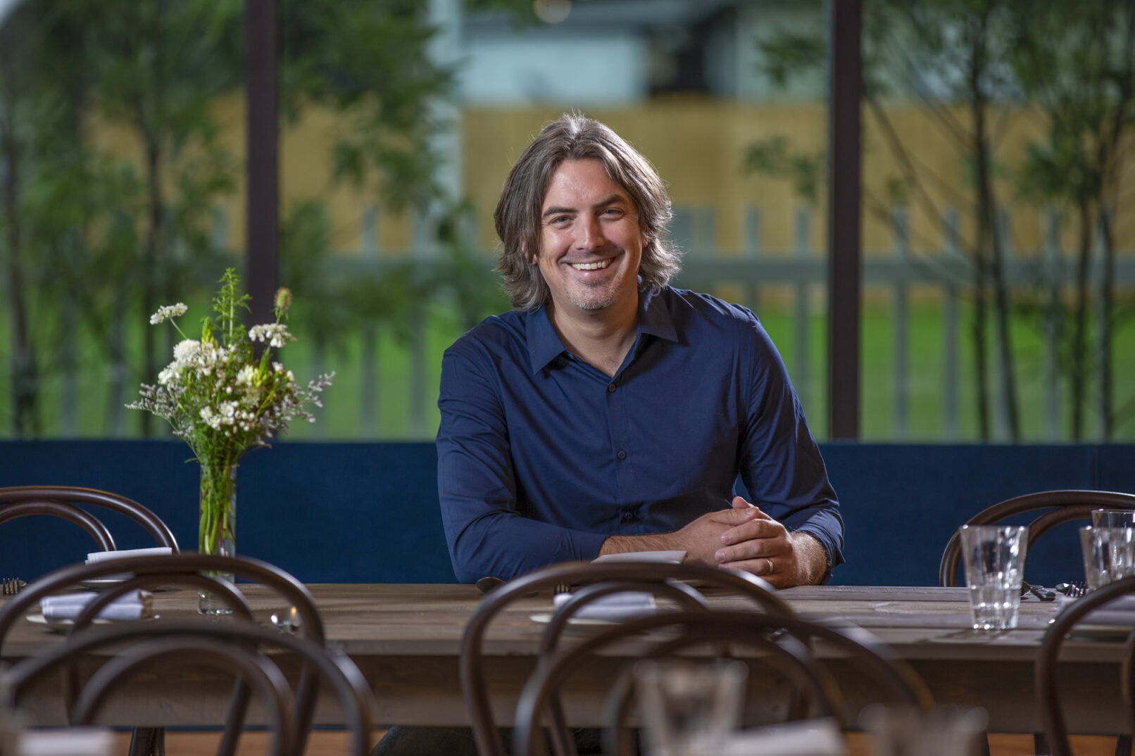 Environmental portrait of a man sitting in a dining room taken for a magazine feature.