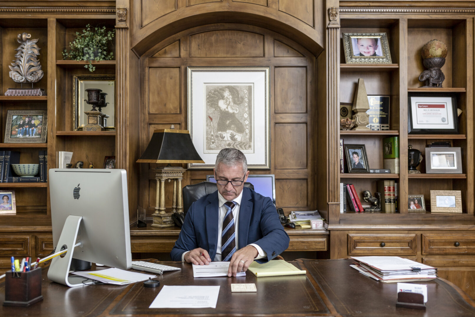 An attorney looks over papers while sitting at his desk.