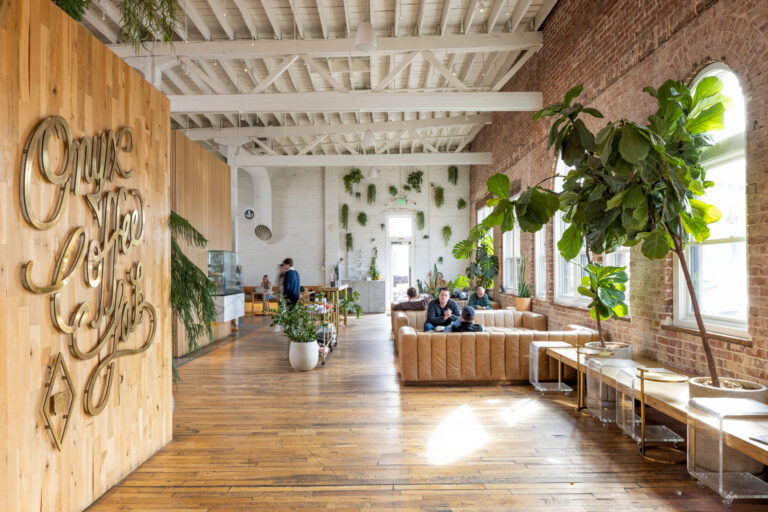 Interior photo of Onxy Coffee in Rogers, Arkansas. The building has hardwood floors, brick and white ceilings.