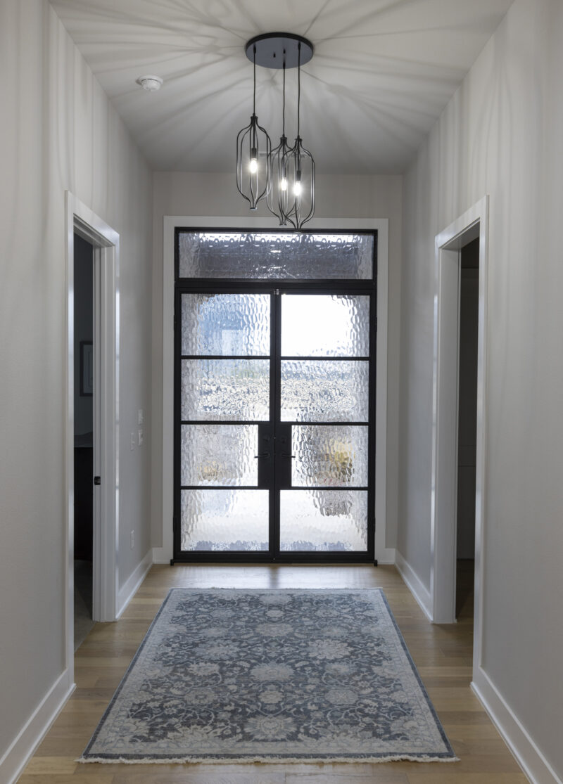 Interior photo of an entrance to a home with a glass door.