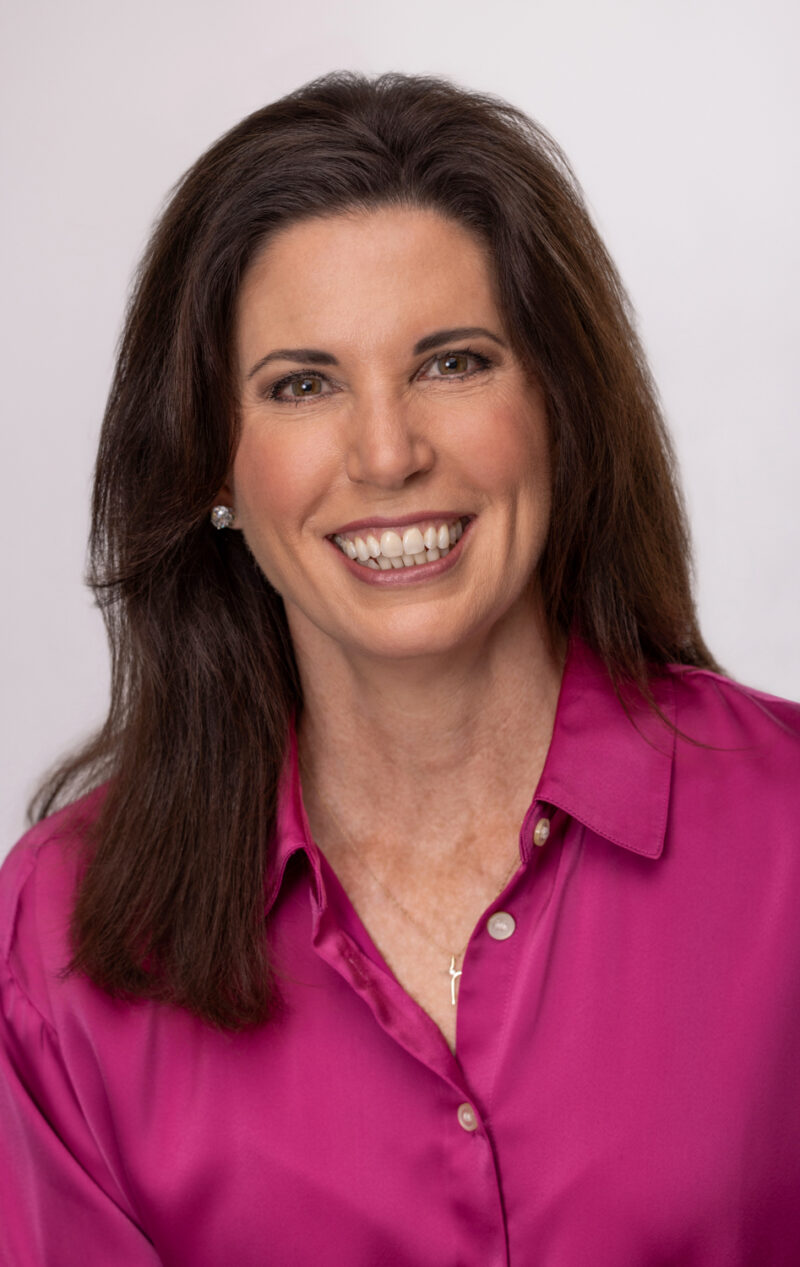Professional studio headshot of a woman wearing a magenta blouse, photographed by Beth Hall Photography in Fayetteville, Arkansas.