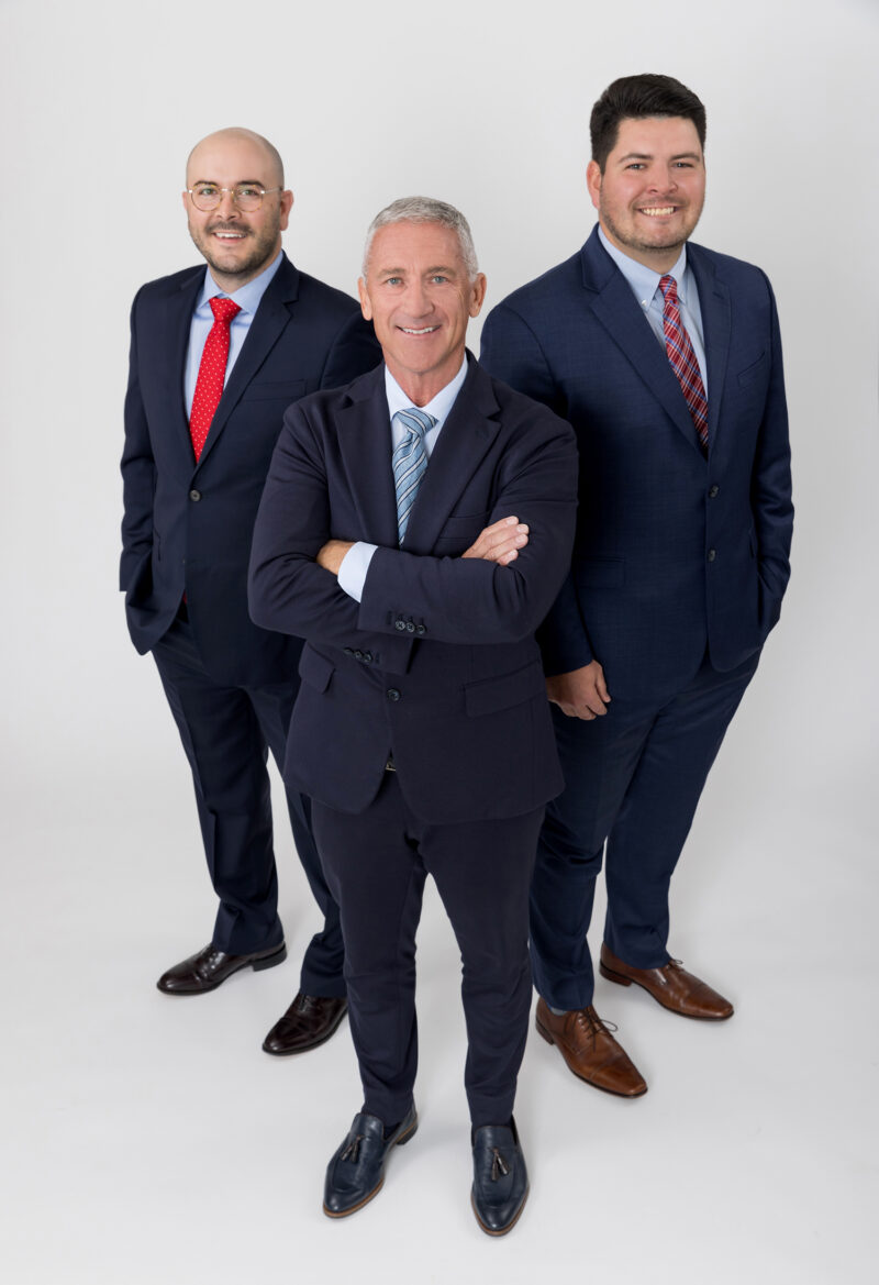 Group portrait of attorneys standing on a white backdrop.