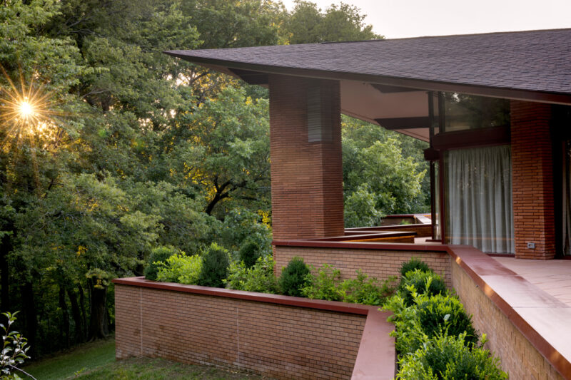 Photo of the exterior of a red brick home designed by E Fay Jones in Fayetteville, Arkansas.