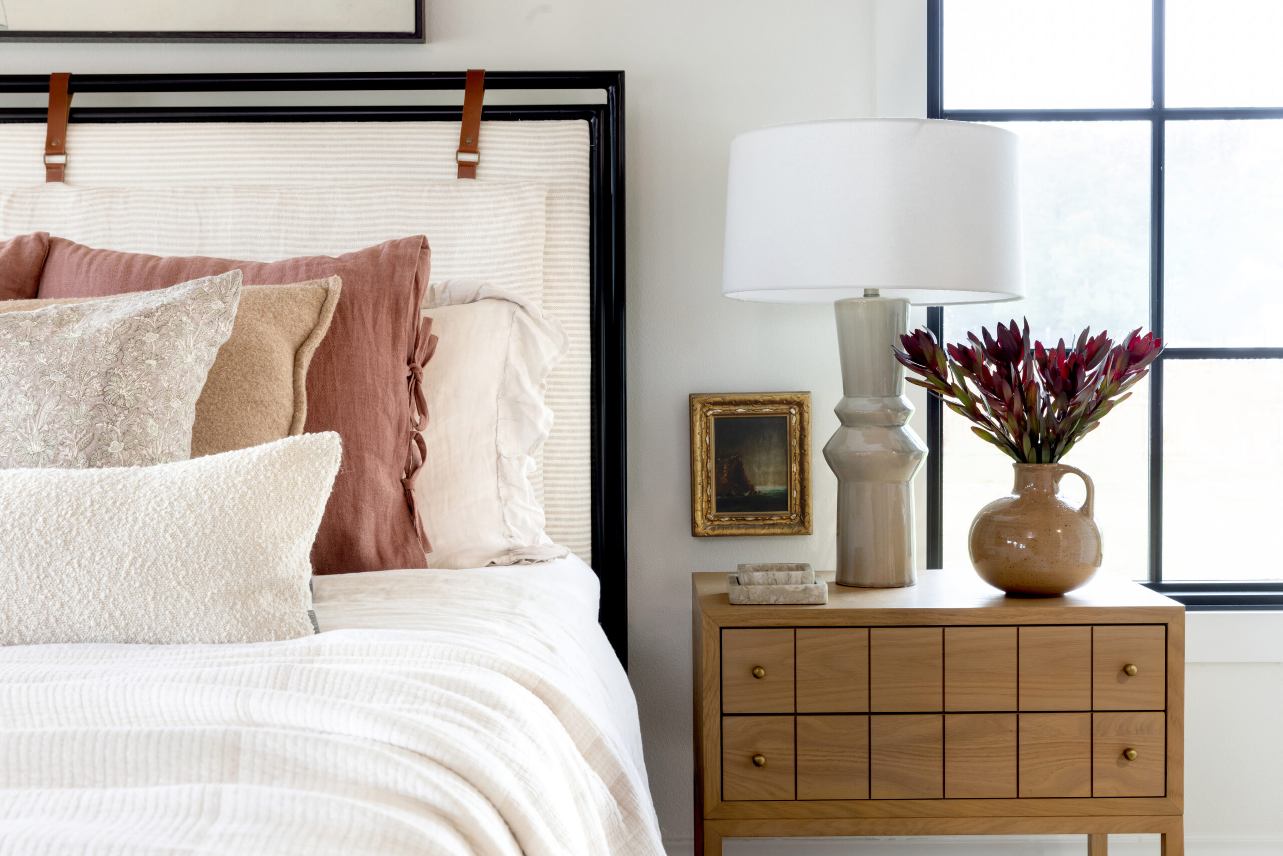 Vignette of a bed and wooden nightstand taken for Sarah Smith Design.