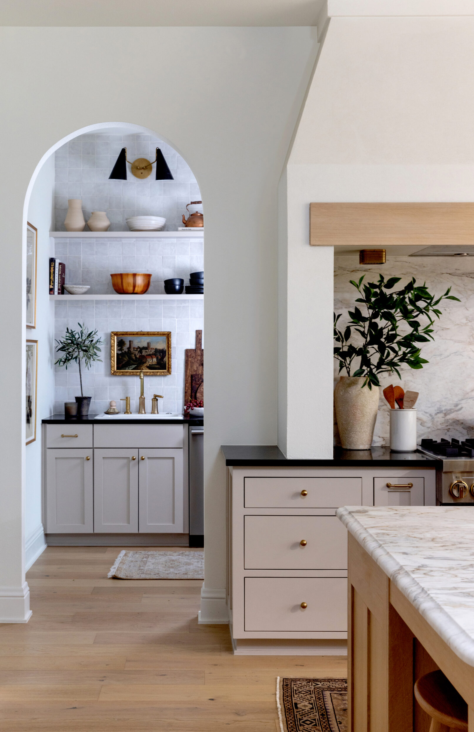 An arched doorway leads to the pantry in this interior photo of a kitchen.