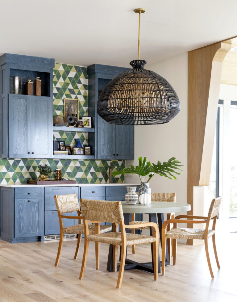 Photo of the interior of a dining area with rattan chairs and blue cabinets.