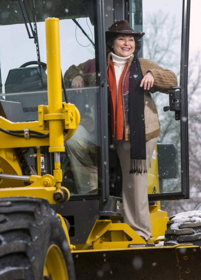 Environmental portrait of Martha D. Moore on a large piece of equipment.