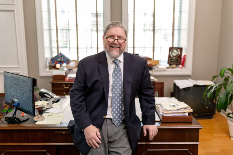 Portrait of an attorney sitting in front of his desk.