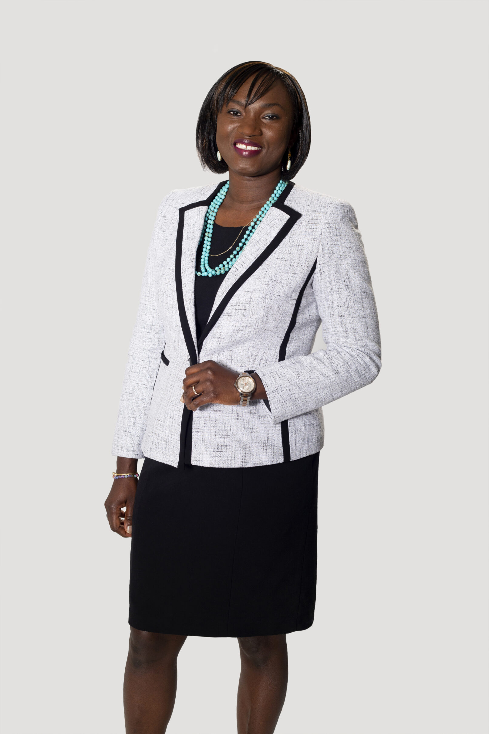 Portrait of a Black woman in a suit taken on a white background.